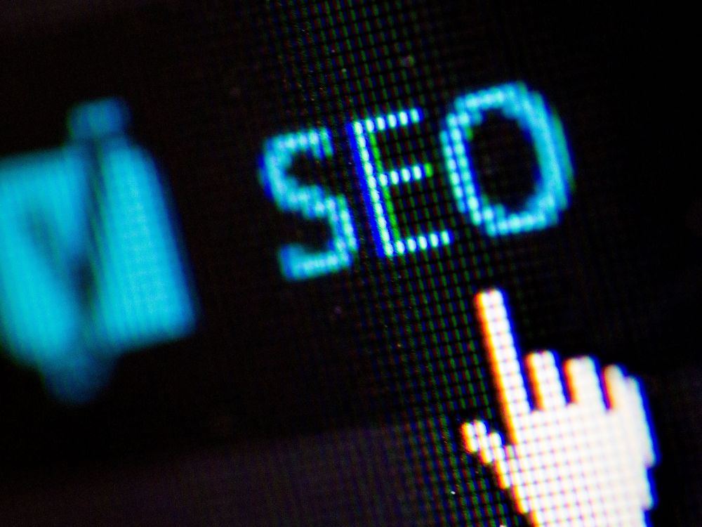 Close de tela de computador exibindo a palavra SEO em letras azuis, com cursor em formato de mão apontando para o texto. Saiba Como captar clientes advocacia pela internet usando SEO