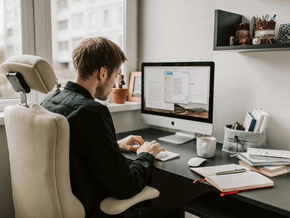 Profissional trabalhando no computador em home office enquanto realiza ações voltadas ao crescimento orgânico no Instagram.