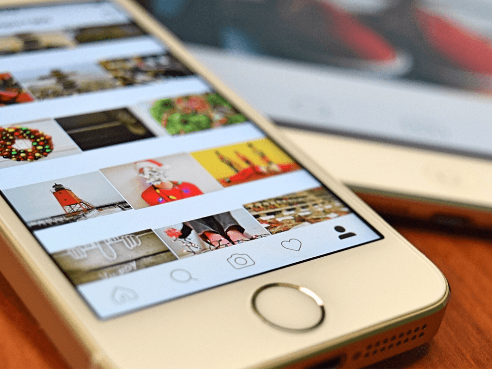 Tela de smartphone com grade de publicações no Instagram, representando organização visual e otimização do perfil.
