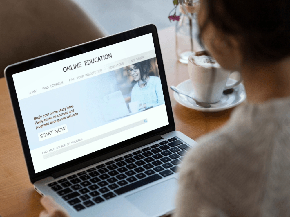 Pessoa utiliza um notebook com página de conteúdo online aberta, ilustrando o acesso a informações por meio de um site.