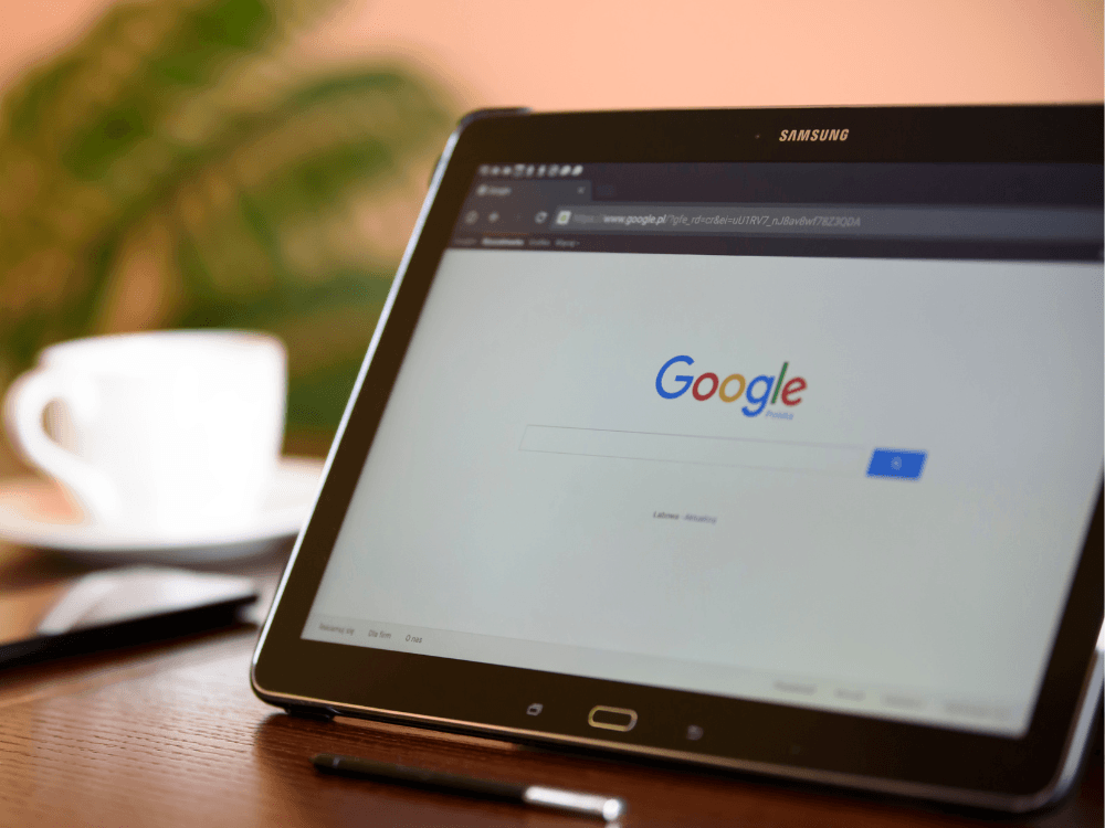 Tablet exibindo a página inicial do Google, representando a busca por sites e a presença de páginas nos resultados orgânicos. Tudo para explicar como fazer para o site aparecer no Google.