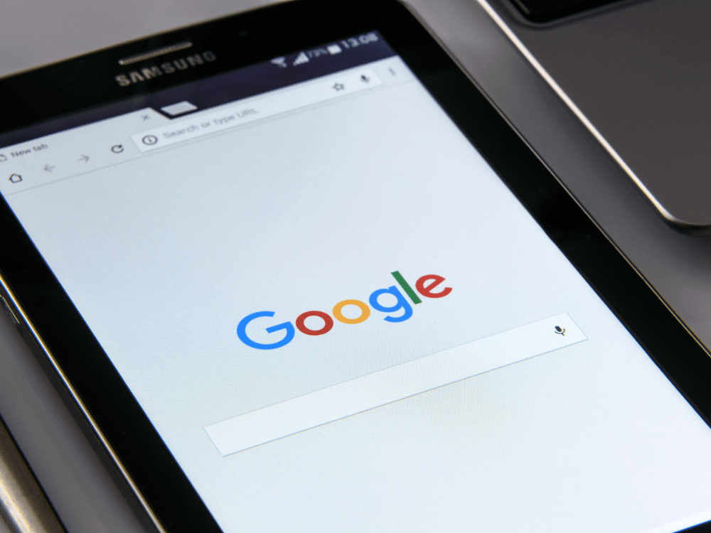 Tablet exibe a página inicial do Google com campo de pesquisa aberto, destacando a importância da presença digital nos dispositivos móveis.