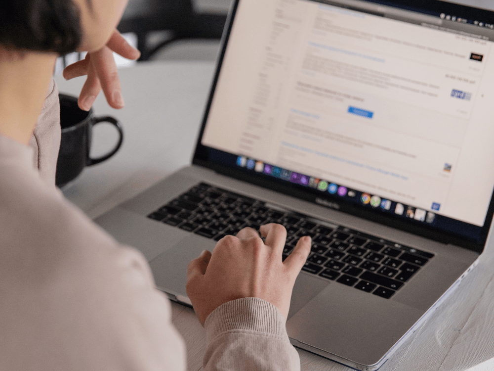 Pessoa utiliza notebook para consultar uma página de resultados de pesquisa, em uma ação relacionada à busca orgânica no Google.