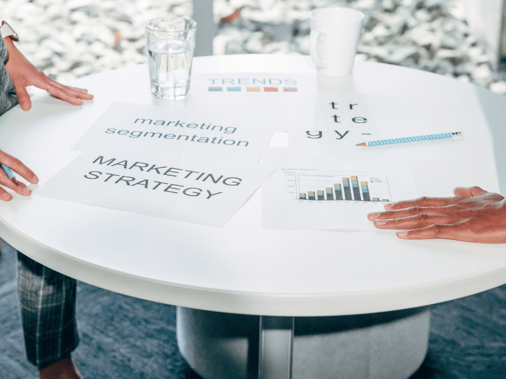 Profissionais analisam gráficos de desempenho e documentos de estratégia de marketing em uma mesa durante o planejamento digital de um site. Tudo para explicar a autoridade de domínio.